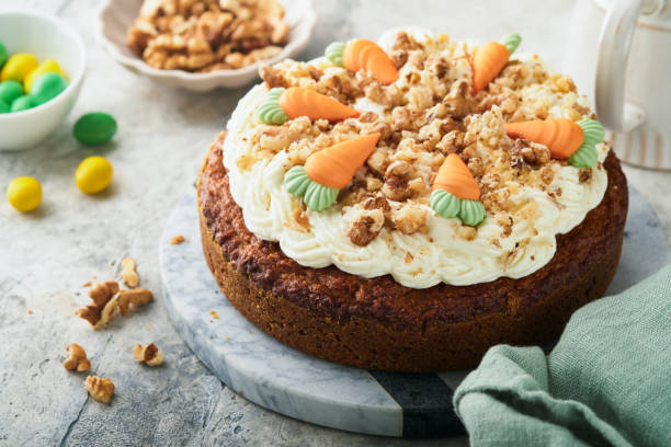 Easter Carrot cake with cream cheese frosting. Delicious carrot cake with walnut and cream cheese frosting on gray concrete background table for festive dinner. Traditional carrot cake. Easter food.