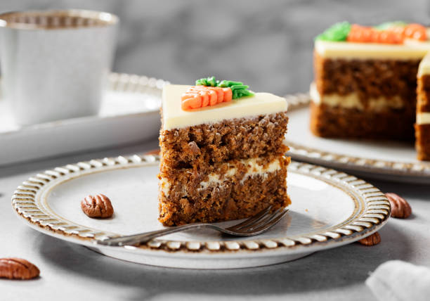 Carrot layered cake with cream cheese frosting decorated with carrots.