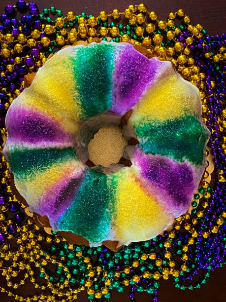 Overhead view of a King Cake, decorated with gold, purple and green beads of Mardi Gras.