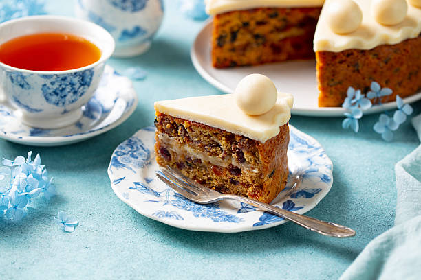 Traditional English Easter simnel cake with cup of tea. Blue background. 